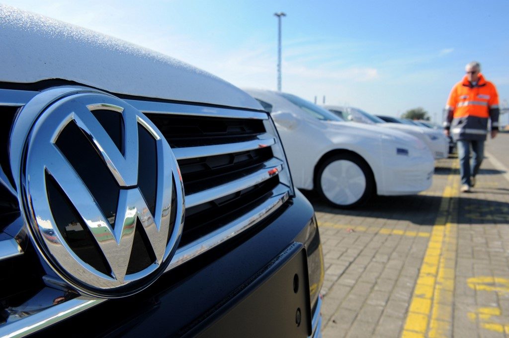 A new Volkswagen (VW) car is seen in the foreground as new cars of the Volkswagen group are parked ready for shipping at the car terminal of the port of Bremerhaven, northwestern Germany, on October 2, 2015. New car registrations in Germany, a key measure of demand in one of the most important sectors of Europe's top economy, rose in September, data showed, amid fears the Volkswagen pollution-cheating scandal could weigh on sales in the sector. AFP PHOTO / DPA / INGO WAGNER +++ GERMANY OUT +++ (Photo by INGO WAGNER / DPA / AFP)